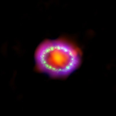 Colorful ring of purple with bright green and blue-green dots surrounding a bright orange blob.