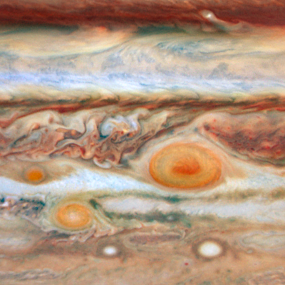 A close-up view of Jupiter’s southern hemisphere. The Great Red Spot is shown on the right side. To the direct left of it is a much smaller red spot. To the lower left of the Great Red Spot is Red Spot Jr., which is smaller than the Great Red Spot.