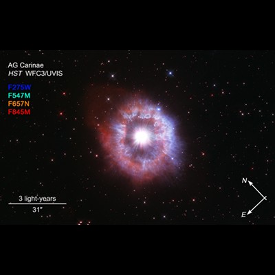 Bright star surrounded by kaleidoscopic rings of red and blue on a dark background with compass arrows, scale bar, and color key for reference.