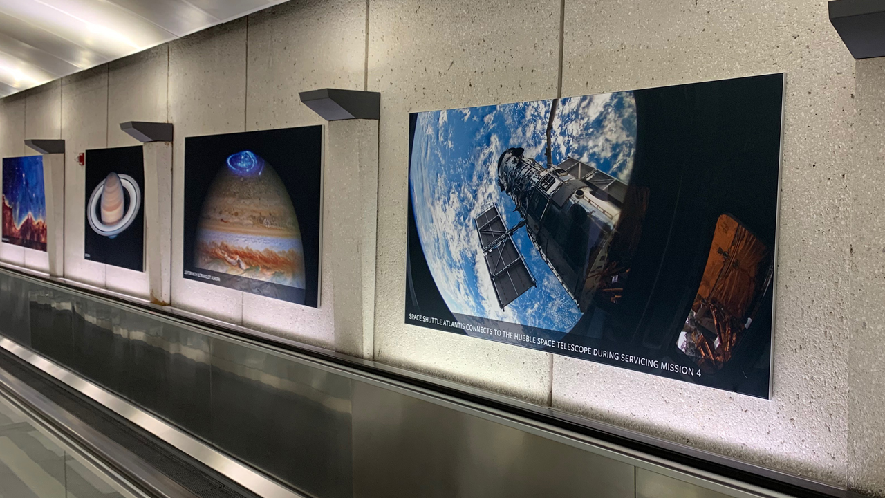 Hubble images and spectra lining a hallway at Dulles International Airport