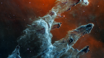 Video titled “The Pillars of Creation in Mid-Infrared Light” zooms in and out to show three key regions: three young stars still embedded in the dusty pillars toward the right and three whiter stars along the left that are outside the pillars.