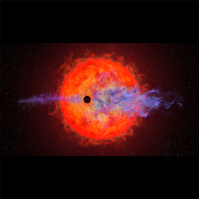 This illustration shows the ball of a red dwarf star. It is mottled with dark spots and finger-like filamentary outbursts. In front is a much smaller black circle representing the silhouette of a planet passing in front of the star. The red dwarf's furious activity is causing the planet's atmosphere to escape into space. This appears as wispy blue filaments along the planet's straight horizontal orbital path. The star is colored a rich red because it is cooler than our Sun.