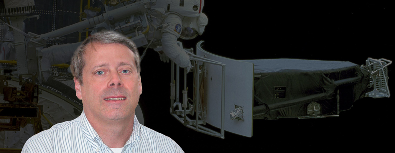 Portrait of Rodger Doxsey. In the background, an astronaut removes the Wide Field and Planetary Camera 1 during the first Hubble servicing mission to make way for the Wide Field and Planetary Camera 2 (WFPC2).